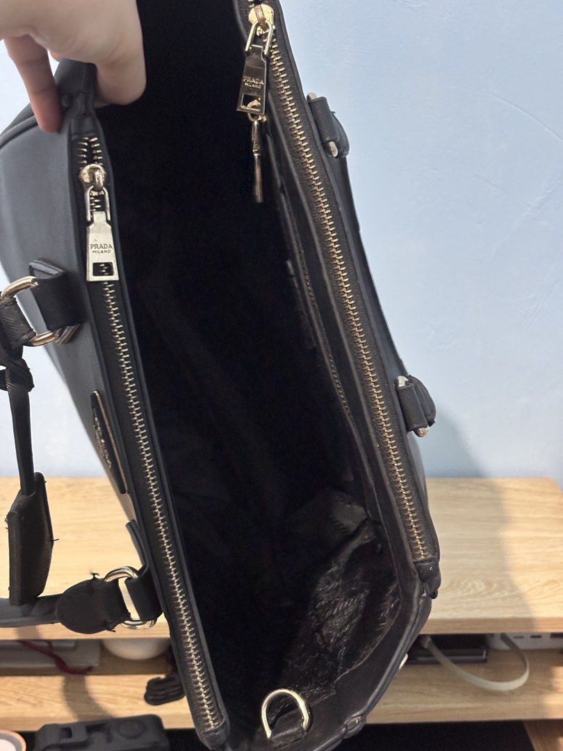 Prada Saffiano Leather Tote Bag Black (Category: Luxury Bags & Wallets) located in Manila. Submitted by maaajesstic (Listing ID 1461802628, Image 2). Description: - Classic black Prada tote bag - Genuine Saffiano leather - Elegant gold hardware details - Two comfortable top handles - Secure zip closure - Spacious interior with multiple compartments - Includes a detachable strap for versatile carrying - Ideal for daily use or travel.