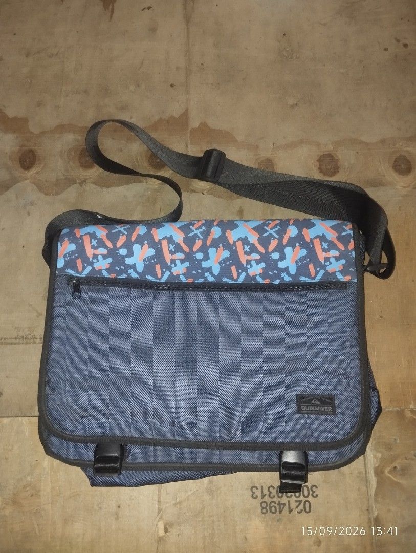 Quiksilver Messenger Bag (Category: Sling Bags) located in Manila. Submitted by thriftjepo01336 (Listing ID 1461887618, Image 1). Description: - Quiksilver messenger bag - Color: Blue with abstract pattern on flap - Features: Main zip compartment, front zip pocket - Adjustable strap for comfortable wear - Ideal for school or everyday use.