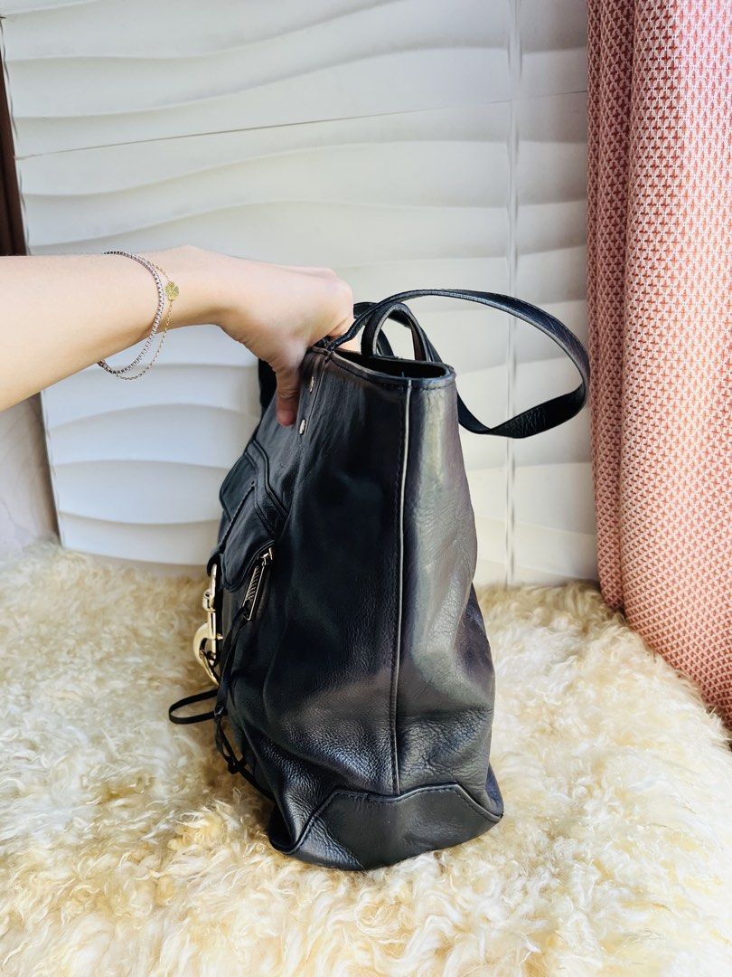 Rebecca Minkoff Black Leather Tote Bag (Category: Tote Bags) located in Davao. Submitted by goodthingsph_ (Listing ID 1462033643, Image 2). Description: - Classic black leather tote bag from Rebecca Minkoff - Spacious interior with patterned lining - Front flap pocket with silver clasp closure - Comfortable top handles for carrying - Perfect for work or everyday casual use.