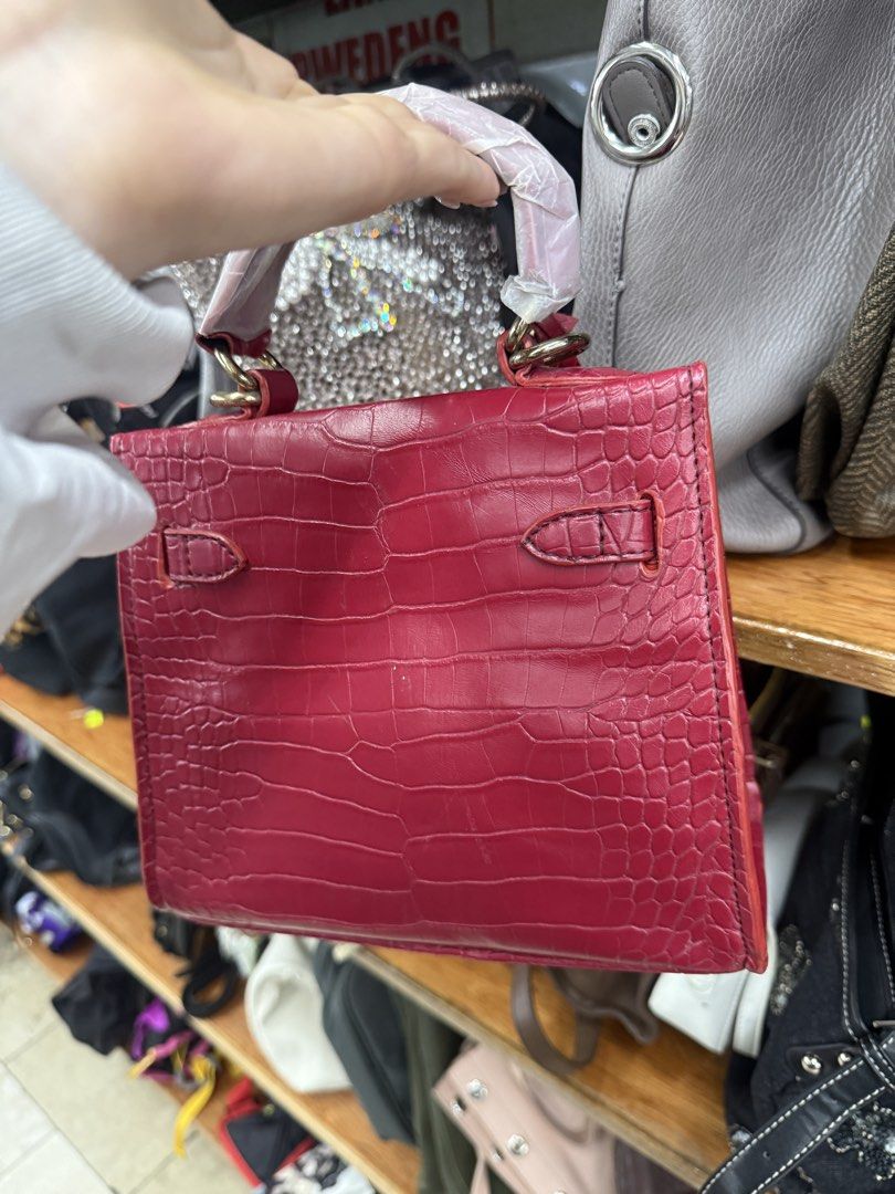 Red Croc Embossed Top Handle Bag (Category: Tote Bags) located in Manila. Submitted by fastlion.584bdf (Listing ID 1461812448, Image 3). Description: - Eye-catching red bag with sophisticated croc-embossed texture. - Elegant gold hardware and secure clasp closure. - Versatile with both a top handle and a detachable strap. - Four metal studs on the bottom to protect the bag's base. - An ideal accessory to add a vibrant pop of color to any outfit..