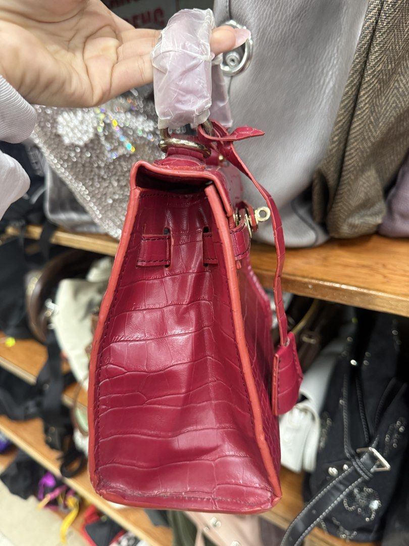 Red Croc Embossed Top Handle Bag (Category: Tote Bags) located in Manila. Submitted by fastlion.584bdf (Listing ID 1461812448, Image 2). Description: - Eye-catching red bag with sophisticated croc-embossed texture. - Elegant gold hardware and secure clasp closure. - Versatile with both a top handle and a detachable strap. - Four metal studs on the bottom to protect the bag's base. - An ideal accessory to add a vibrant pop of color to any outfit..