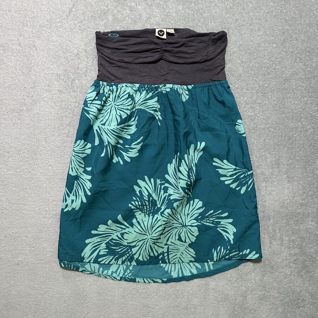 Roxy Strapless Floral Dress M/M 2000s edition (Category: Dresses) located in Villaverde. Submitted by bakatzy_secondhand_garments (Listing ID 1461844320, Image 1). Description: - Roxy strapless dress - Size: M/M - Top: Dark grey, ruched - Skirt: Teal and light green floral print - Features: Elasticated waist - Ideal for: Beach days, casual wear.