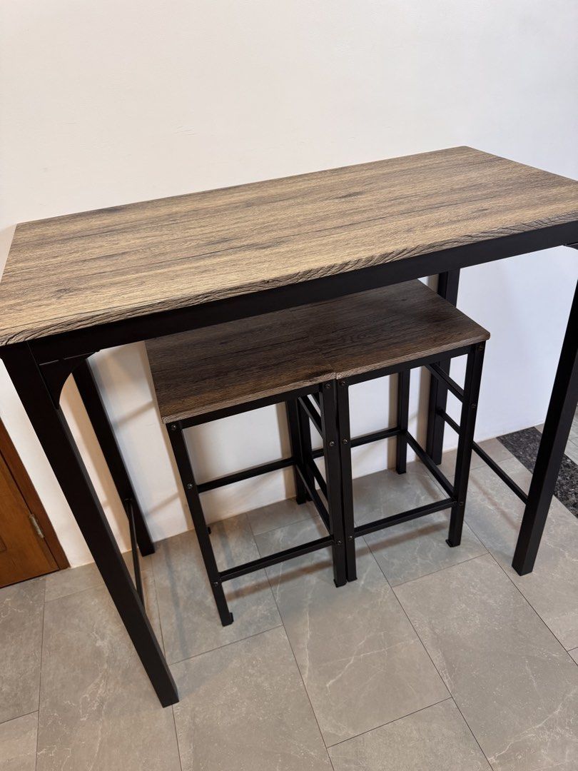 Rustic Wood Bar Table with 2 Stools (Category: Tables & Sets) located in Rizal. Submitted by soldnshipped (Listing ID 1461878272, Image 3). Description: Dimensions: Table - L100cm x W50cm x H98cm Chair- L35cm x W35cm x H68cm With very minor chips on some corners Fixed price plus delivery fee Compact bar table and two stools set - Wood-look tabletop with a sleek black metal frame - Ideal for small spaces like kitchens or dining nooks - Stools tuck