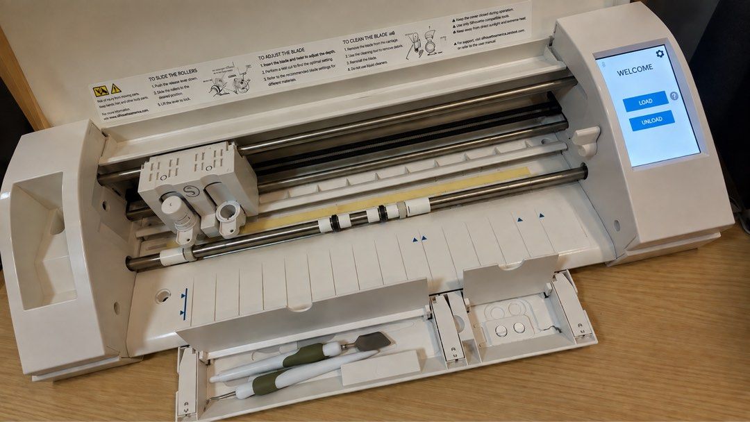 Silhouette Cameo 3 Electronic Cutting Machine with Accessories (Category: Office & Business Technology) located in Navotas City. Submitted by kirbieandkyle (Listing ID 1461914769, Image 3). Description: - Silhouette Cameo 3 electronic cutting machine - Features a touchscreen - Tested and ready to use - Original adapter and cable included - Comes with weeding hook and spatula - Free cutting mat included - Ideal for various crafting projects.