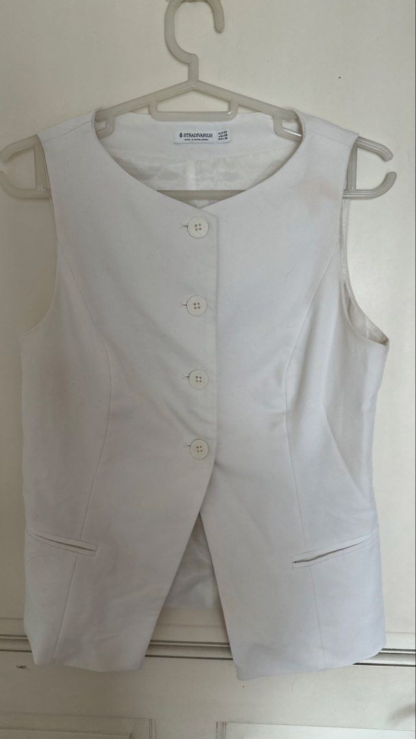 Stradivarius White Sleeveless Button-Up Vest (Category: Sleeveless) located in Mandaluyong City. Submitted by yv.stuff (Listing ID 1461831075, Image 2). Description: - White sleeveless vest from Stradivarius - Button-up front with two pocket details - Made in Bangladesh - Size XS - Perfect for layering over tops or dresses - Can be worn open or closed for a sharp look.