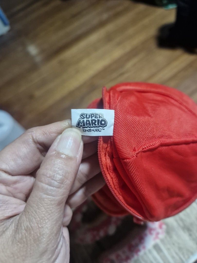 Super Mario Plush Coin Pouch Keychain Red (Category: Character Goods) located in Manila. Submitted by veelafiera (Listing ID 1461946336, Image 3). Description: - Officially licensed Nintendo Mario hat plush coin pouch. - Features the iconic 'M' logo. - Zipper closure for secure storage. - Compact size, ideal for attaching to bags or keys. - Perfect for holding coins, earbuds, or other small essentials..