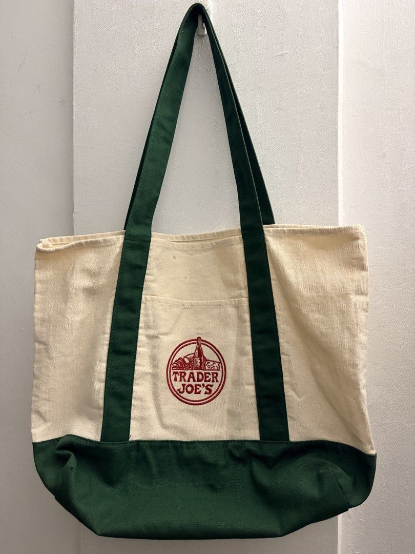 Trader Joe's Canvas Tote Bag (Category: Tote Bags) located in Manila. Submitted by finderskeepersmnl_092026 (Listing ID 1461957131, Image 1). Description: - Classic Trader Joe's canvas tote bag - Cream colored body - Dark green handles and base - Features iconic embroidered Trader Joe's logo - Ideal for grocery shopping or everyday errands - Durable and reusable design.
