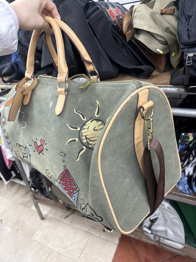 travel bag (Category: Beach Bags) located in Manila. Submitted by fastlion.584bdf (Listing ID 1461815140, Image 2). Description: - Unique travel duffel bag - Features a charming hand-painted design (sun, house, airplane, etc.) - Durable olive green canvas material - Stylish tan leather trim and handles - Spacious interior for your essentials - issue posted.