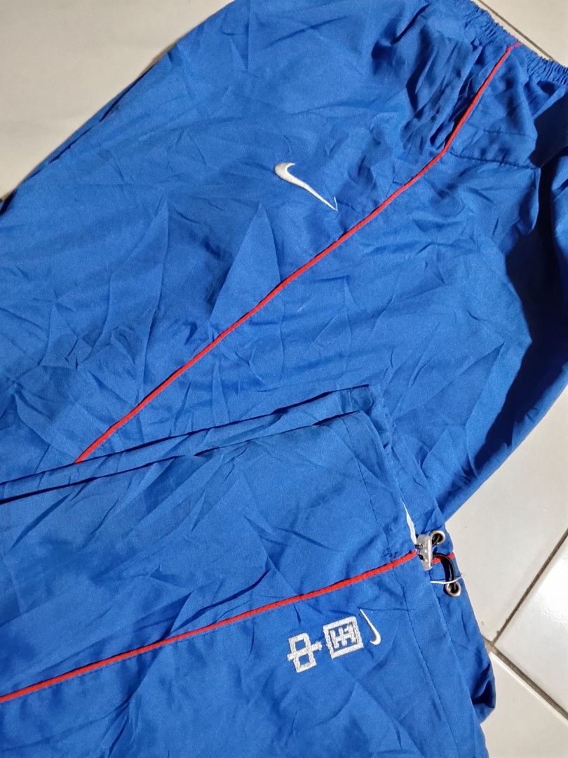 Vintage y2k Nike pants embroid (Category: Joggers) located in Cavite. Submitted by ara.thrifts (Listing ID 1461813604, Image 2). Description: - Blue Nike track pants - Chinese characters and Nike logo on the left leg 2xl width "17" length "41" no issue bnew 10/10 cr.