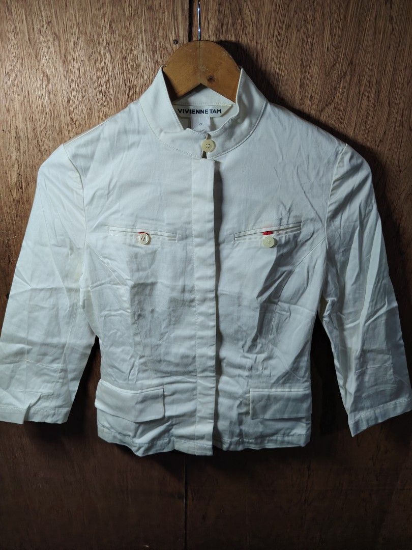 Vivienne Tam White Cropped Jacket Size 0 (Category: Coats, Jackets and Outerwear) located in Baguio. Submitted by angeloshoppebaguio2600 (Listing ID 1461981567, Image 1). Description: - Vivienne Tam cropped jacket - Color: White - Material: 96% Cotton, 4% Spandex - Style: Mandarin collar, button-up front - Sleeves: Three-quarter length - Pockets: Two front pockets with button closure - Detail: Small red accent on pocket - Care: Professional dry c