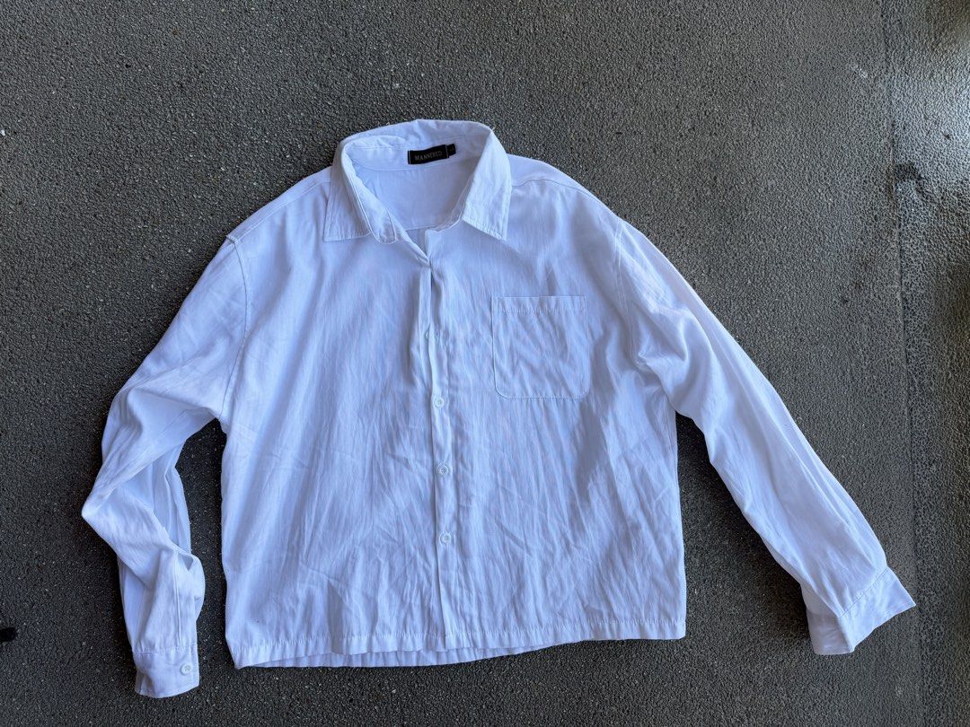 White Boxy Cropped Long Sleeve Button Up Shirt (Category: Tshirts & Polo Shirts ) located in San Fernando. Submitted by houseof_jj (Listing ID 1462030913, Image 1). Description: USED ONCE SIZE: L - White long sleeve shirt from MANNERED - Features a collar and a single chest pocket - Button-up front closure - Relaxed fit for comfort - Versatile for casual wear or layering - Easy to style with any outfit.