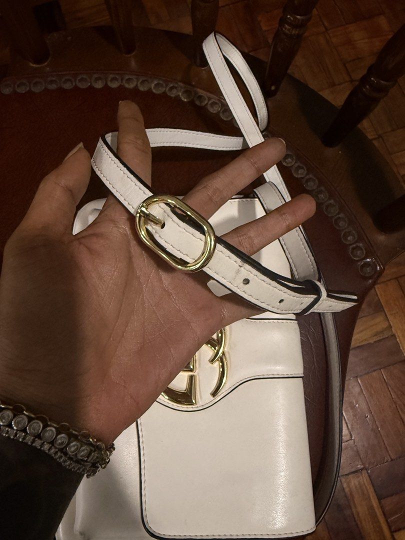 White Gucci sling bag (Category: Luxury Bags & Wallets) located in Pinamalayan. Submitted by braveheartfiftyfive (Listing ID 1461872532, Image 3). Description: - white leather Gucci shoulder bag - Iconic gold-tone GG logo hardware - Adjustable shoulder strap with buckle - Interior: zip pocket and main compartment - Secure magnetic snap closure - Minor marks on exterior leather (please check photos) - Interior is clean.
