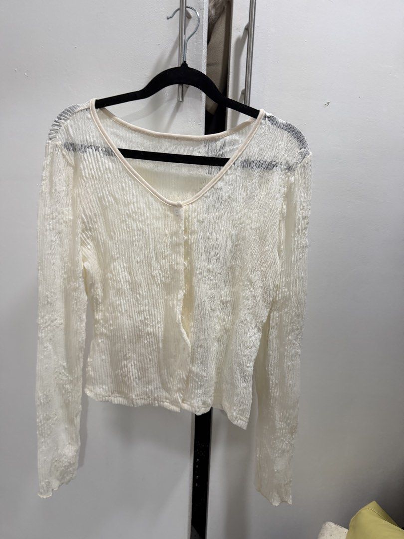 White Lace Button-Up Cardigan (Category: Coats, Jackets and Outerwear) located in Pasig City. Submitted by miss_abuelita (Listing ID 1461872889, Image 3). Description: - Sheer white lace cardigan - Long sleeves - V-neckline - Button-up front - Textured, crinkled fabric with subtle floral pattern - Ideal for layering over tops or dresses.