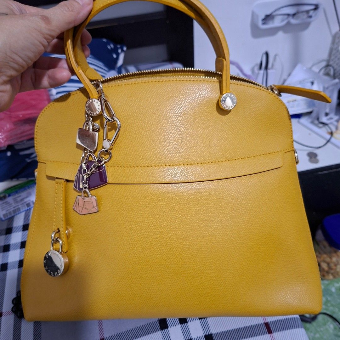 Yellow Leather Handbag with Charms (Category: Shoulder Bags) located in Las Pinas. Submitted by jgz21 (Listing ID 1461813661, Image 1). Description: - Bright yellow leather handbag - Versatile: Top handle and detachable shoulder strap - Adorable metal charms included - Secure zip-top closure - Elegant gold hardware details - Protective feet on the bottom - Ideal for daily use.