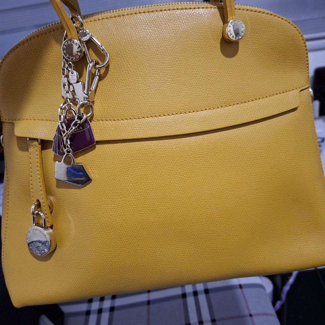 Yellow Leather Handbag with Charms (Category: Shoulder Bags) located in Las Pinas. Submitted by jgz21 (Listing ID 1461813661, Image 2). Description: - Bright yellow leather handbag - Versatile: Top handle and detachable shoulder strap - Adorable metal charms included - Secure zip-top closure - Elegant gold hardware details - Protective feet on the bottom - Ideal for daily use.