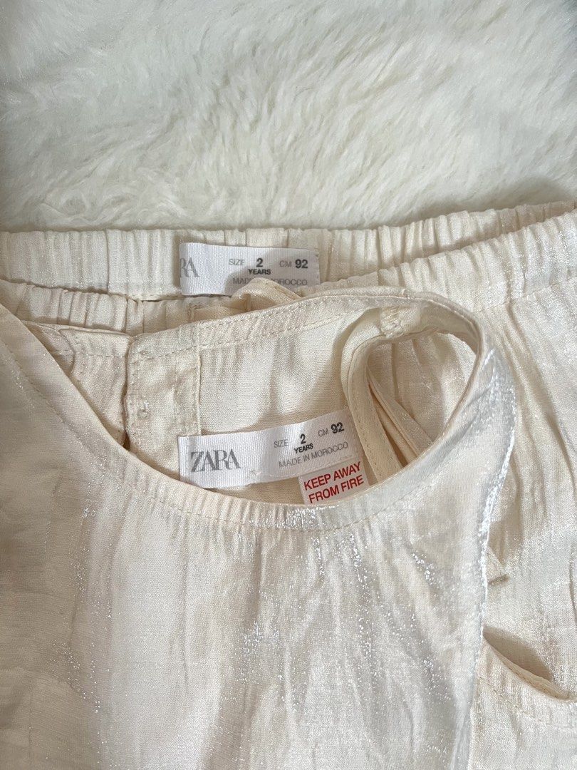 Zara Satin Ruffle coords (Category: Babies & Kids Fashion) located in Quezon City. Submitted by raidmystyle (Listing ID 1461853265, Image 3). Description: - Adorable Zara cream set for kids. - Includes a sleeveless top with a ruffled hem. - Matching culottes with an elastic waistband for comfort. - Both pieces feature a subtle metallic thread detail. - Perfect for parties and special occasions..