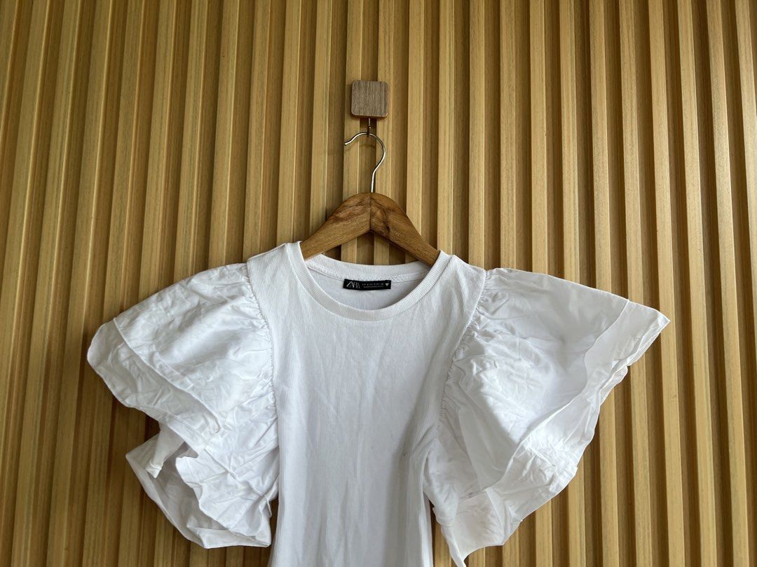 Zara White Puff Sleeve Bodysuit (Category: Others Tops) located in Lipa City. Submitted by thyra06 (Listing ID 1461846866, Image 3). Description: - Zara white bodysuit - Features dramatic puff sleeves - Ribbed texture on the main body - Convenient snap closure at the bottom - Perfect for dressing up or down, pair with jeans or a skirt.