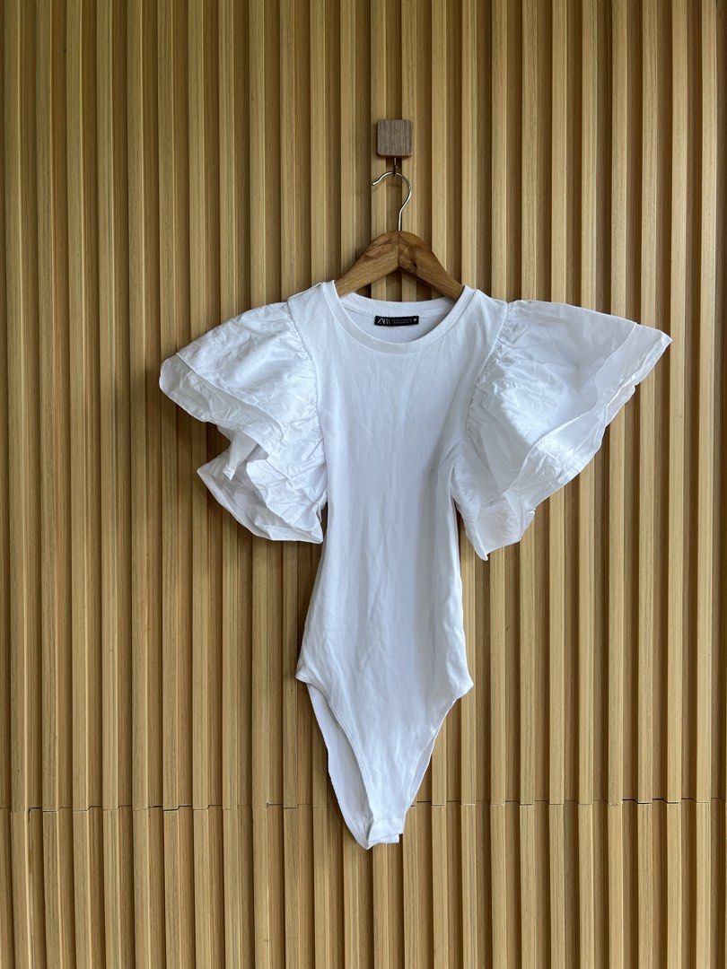 Zara White Puff Sleeve Bodysuit (Category: Others Tops) located in Lipa City. Submitted by thyra06 (Listing ID 1461846866, Image 2). Description: - Zara white bodysuit - Features dramatic puff sleeves - Ribbed texture on the main body - Convenient snap closure at the bottom - Perfect for dressing up or down, pair with jeans or a skirt.
