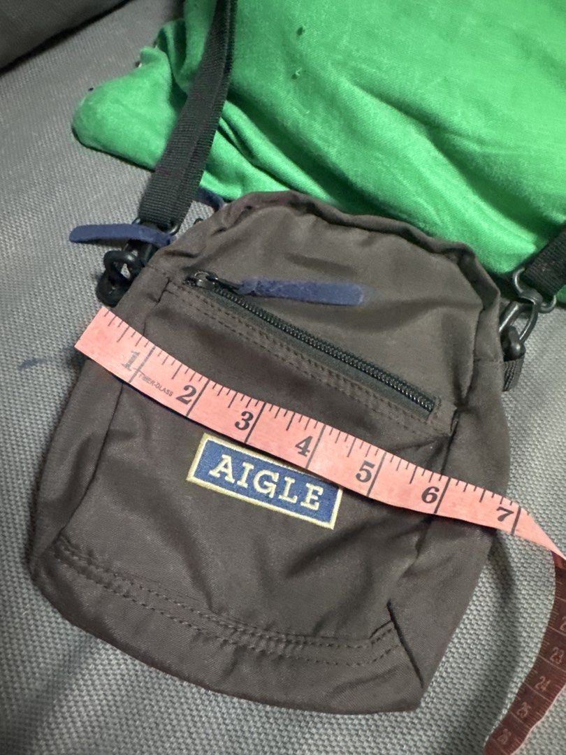 2027 AIGLE Brown Crossbody Bag (Category: Cross-body Bags) located in Silang. Submitted by sari2bilina (Listing ID 1462155659, Image 2). Description: - Brand: AIGLE - Color: Brown - Style: Crossbody bag - Features: Main zippered compartment, front zippered pocket - Strap: Adjustable - Size: Small and compact, approx. 7 inches tall x 5 inches wide - Ideal for: Carrying essentials.