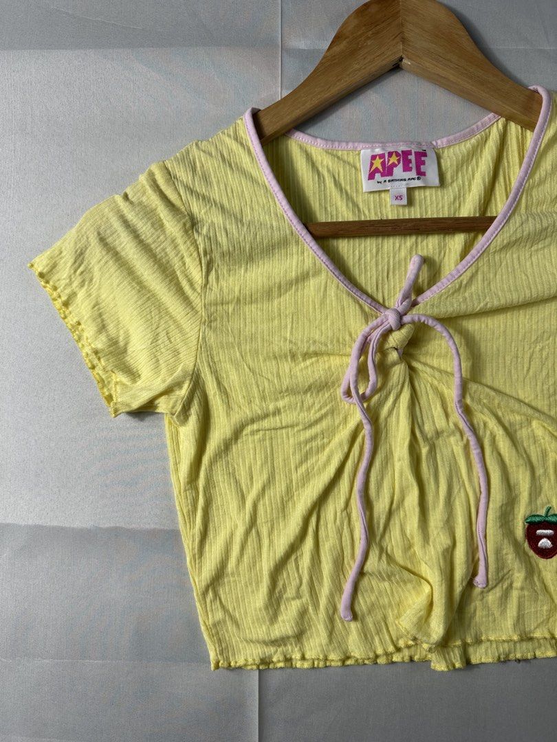 Aape Y2K Cropped Shirt (Category: Others Tops) located in Cabanglasan. Submitted by thefashiongarage.co (Listing ID 1462131944, Image 3). Description: Title - Aape Y2K Cropped Shirt Model/Name - Aape Cropped Size on Tag - XS Conditiion - Excellent Condition - No issue Dimension (LxWxH) - Category- Cropped Shirt Fitting - Made in - China Material - 92% Viscose / 8% Spandex Color - Yellow Design - Aape Cherry Patch Embroide Year - Inclusion - Shirt