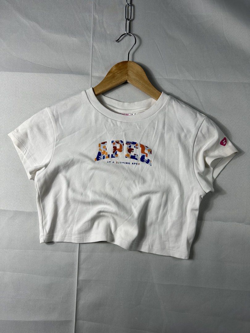 Aape Y2K White Printed Cropped Shirt (Category: Others Tops) located in Cabanglasan. Submitted by thefashiongarage.co (Listing ID 1462132691, Image 1). Description: Title - Aape Y2K Printed Cropped Shirt Model/Name - Cropped Shirt Size on Tag - Small Conditiion - Excellent Condition Dimension (LxWxH) - 16x14.5 Inches Category- Cropped Shirt Fitting - True to size Made in - China Material - 97% Cotton/ 3% Spandex Color - White Design - Printed Scr