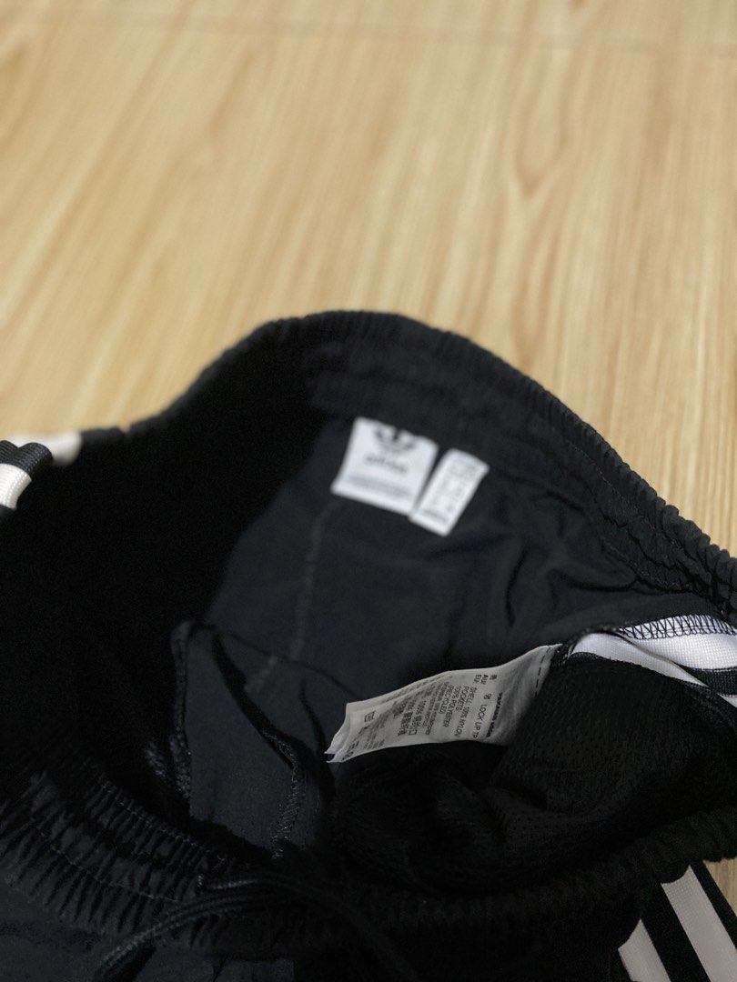 Adidas Black Track Pants with White Stripes (Category: Other Bottoms) located in Davao. Submitted by jayelcarba61168 (Listing ID 1462164148, Image 3). Description: - Classic black Adidas track pants - Iconic white three stripes down the sides - Adidas trefoil logo on left leg and right hip - Elastic waistband with drawstring for adjustable fit - Zippered pockets for secure storage - Versatile for casual wear or sports activities.