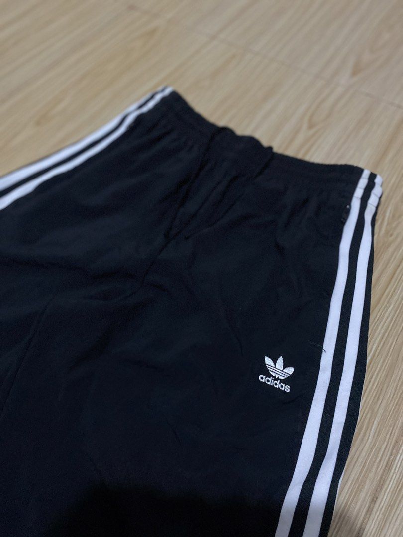 Adidas Black Track Pants with White Stripes (Category: Other Bottoms) located in Davao. Submitted by jayelcarba61168 (Listing ID 1462164148, Image 2). Description: - Classic black Adidas track pants - Iconic white three stripes down the sides - Adidas trefoil logo on left leg and right hip - Elastic waistband with drawstring for adjustable fit - Zippered pockets for secure storage - Versatile for casual wear or sports activities.