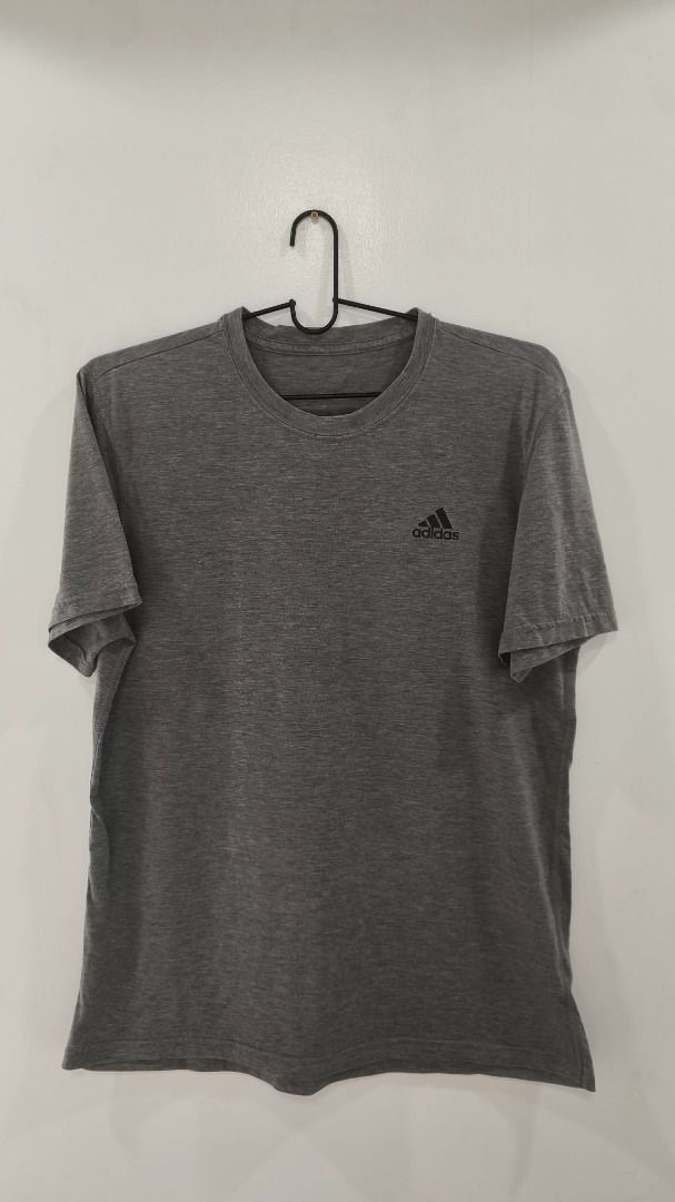 Adidas Dry-fit (Category: Activewear) located in Quezon City. Submitted by secondtonone12 (Listing ID 1462054614, Image 1). Description: Style: Short-sleeve crew-neck performance T-shirt designed for sports, training, and everyday athletic wear. Construction: Raglan-style shoulder seams with contrasting darker gray panels extending from the shoulders down the sides. Fabric Appearance: Lightweight heathered knit with a slightly textured finish, ty