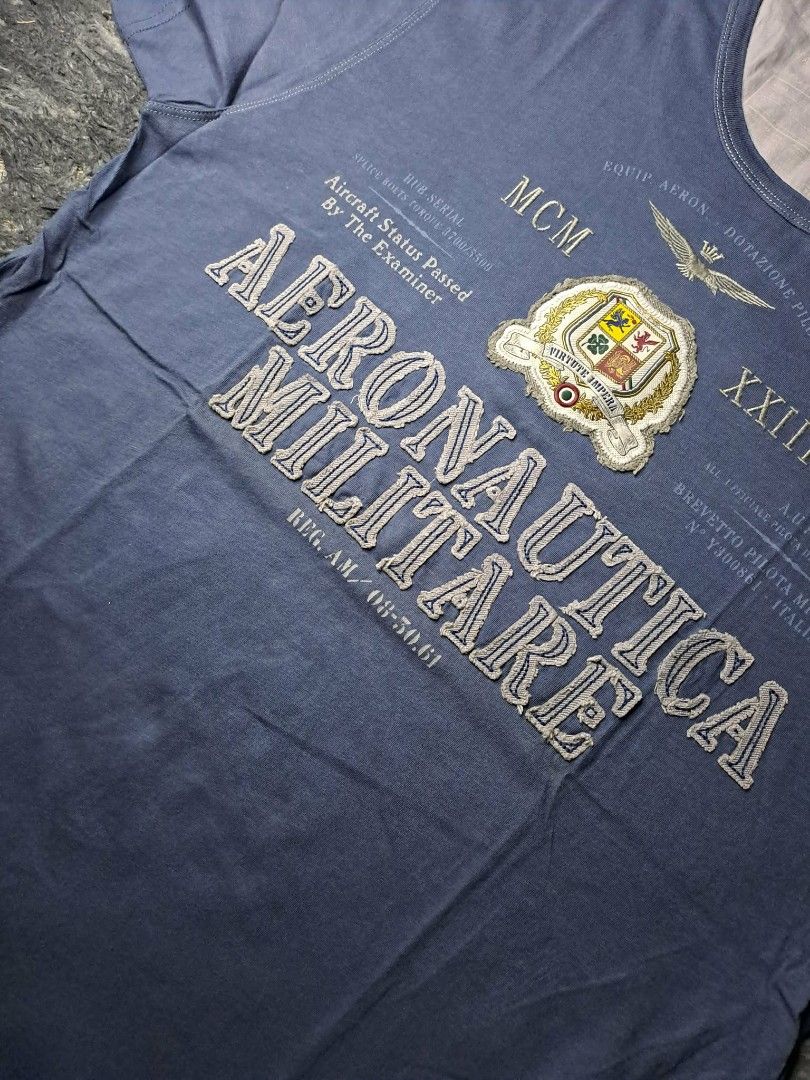 Aeronautica Militare (Category: Tshirts & Polo Shirts ) located in Manila. Submitted by yaseen__73 (Listing ID 1462204704, Image 3). Description: Aeronautica Militare crew-neck T-shirt in navy blue. It features stylized graphics inspired by the Italian Air Force, including military emblems, Roman numerals, and aviation text overlays. Wearing Size : M - L Dimensions : See Photo Color Rate : 10/10 Flawless Brand New Condition - P R E O W N E D MOP 