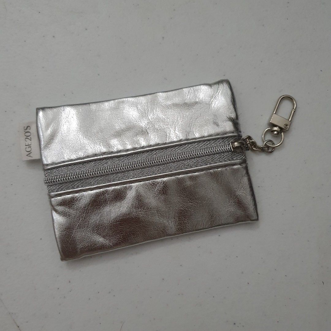 AGE20'S Silver Metallic leather Coin Pouch with Keychain (Category: Purses & Pouches) located in Paranaque City. Submitted by cobien (Listing ID 1462192869, Image 1). Description: - Cute silver coin pouch from AGE20'S - Metallic finish catches the light - Zipper closure - Keychain clip included - Small and compact size - Ideal for coins or small essentials - Perfect for attaching to a bag.