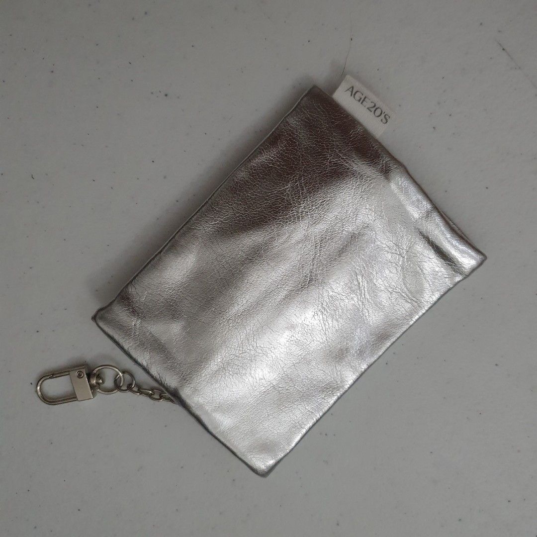 AGE20'S Silver Metallic leather Coin Pouch with Keychain (Category: Purses & Pouches) located in Paranaque City. Submitted by cobien (Listing ID 1462192869, Image 2). Description: - Cute silver coin pouch from AGE20'S - Metallic finish catches the light - Zipper closure - Keychain clip included - Small and compact size - Ideal for coins or small essentials - Perfect for attaching to a bag.