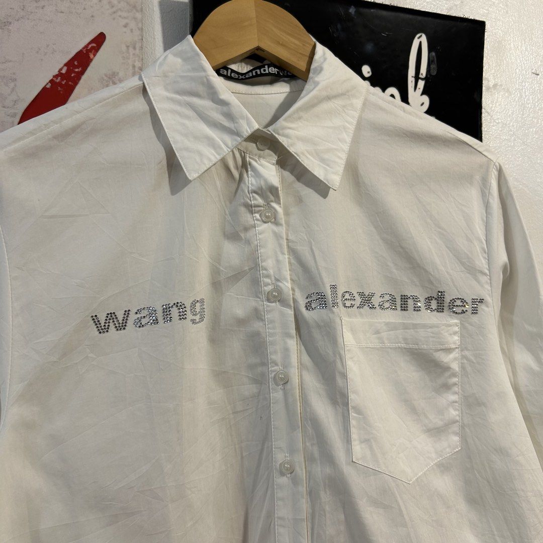 Alexander Wang White Rhinestone Logo Button Up Shirt (Category: Tshirts & Polo Shirts ) located in Manila. Submitted by jakes_thrift_shop (Listing ID 1462036730, Image 3). Description: - Alexander Wang white button-up shirt - Features a sparkling rhinestone logo on the front - Eye-catching graphic smiley face print on the back - Made from comfortable and breathable 100% cotton - Versatile for both casual outings and making a fashion statement.