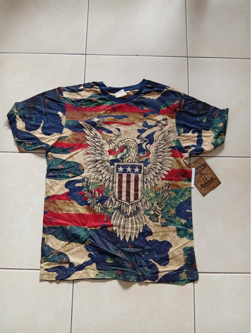 American Eagle Camo T-shirt (Category: Tshirts & Polo Shirts ) located in Mandaluyong City. Submitted by luna_elisse (Listing ID 1462074248, Image 1). Description: - Eye-catching graphic tee with American flag and eagle design. - Features a full camouflage pattern. - Classic short sleeves and crew neck. - Estimated size: Medium. - Ideal for everyday casual wear. -Price:600+sf -MOP: Gcash/BDO/GoTyme -Location: Mandaluyong -RFS: gift/decluttering.