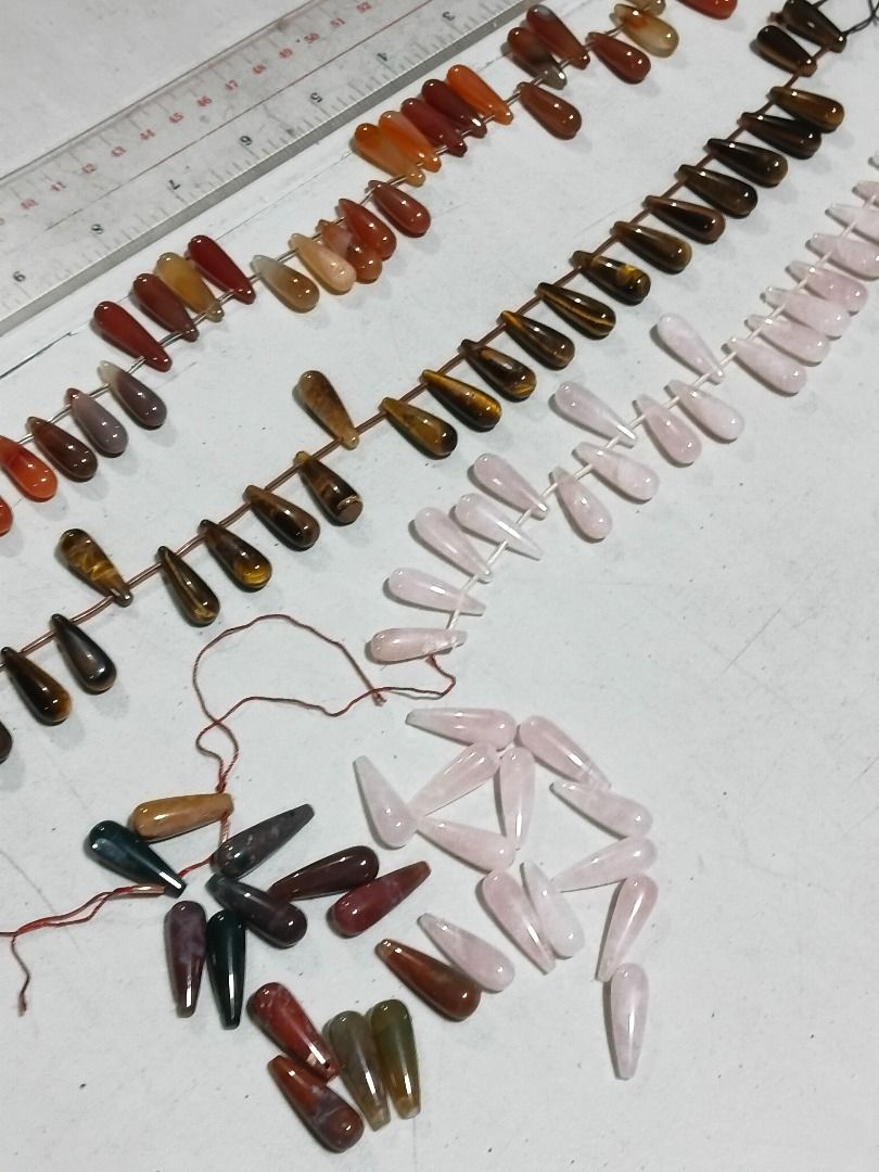 Assorted Gemstone Teardrop Beads for Jewelry Making (Category: Craft Supplies & Tools) located in Marikina City. Submitted by my-an (Listing ID 1462201500, Image 1). Description: - Assorted elongated teardrop-shaped natural stone beads - Includes Rose Quartz, Tiger's Eye, Carnelian, and possibly Agate/Jasper - Perfect for DIY necklaces, bracelets, and earrings - Strung on thread for convenient handling - Ruler included in photos for size referenc