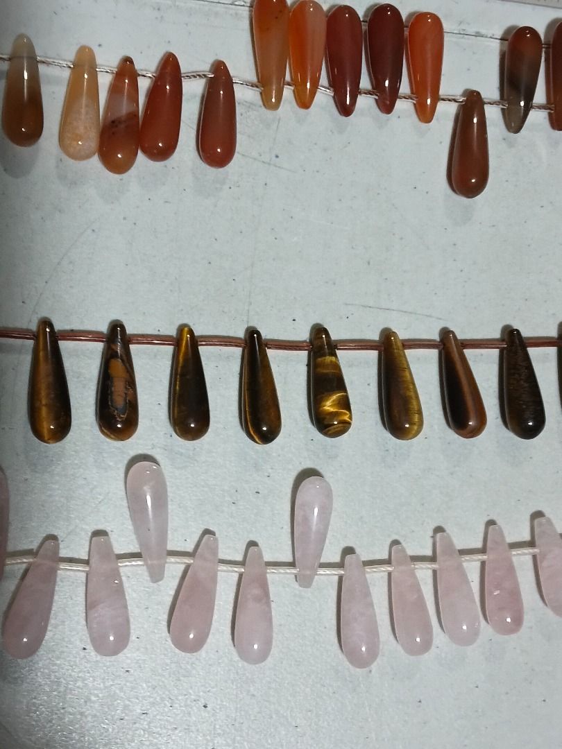 Assorted Gemstone Teardrop Beads for Jewelry Making (Category: Craft Supplies & Tools) located in Marikina City. Submitted by my-an (Listing ID 1462201500, Image 2). Description: - Assorted elongated teardrop-shaped natural stone beads - Includes Rose Quartz, Tiger's Eye, Carnelian, and possibly Agate/Jasper - Perfect for DIY necklaces, bracelets, and earrings - Strung on thread for convenient handling - Ruler included in photos for size referenc