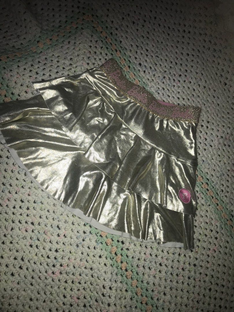 Barbie Gold Ruffle Skirt Size 2 (Category: Babies & Kids Fashion) located in Caloocan City. Submitted by julie_shooooopppp (Listing ID 1462170875, Image 2). Description: - Adorable gold ruffle skirt from Barbie - Features a sparkly pink waistband - Little Barbie logo detail on the side - Perfect for dress-up play or parties - Made in China - Size 2 - Recommended height: 92cm - Recommended waist: 54cm.
