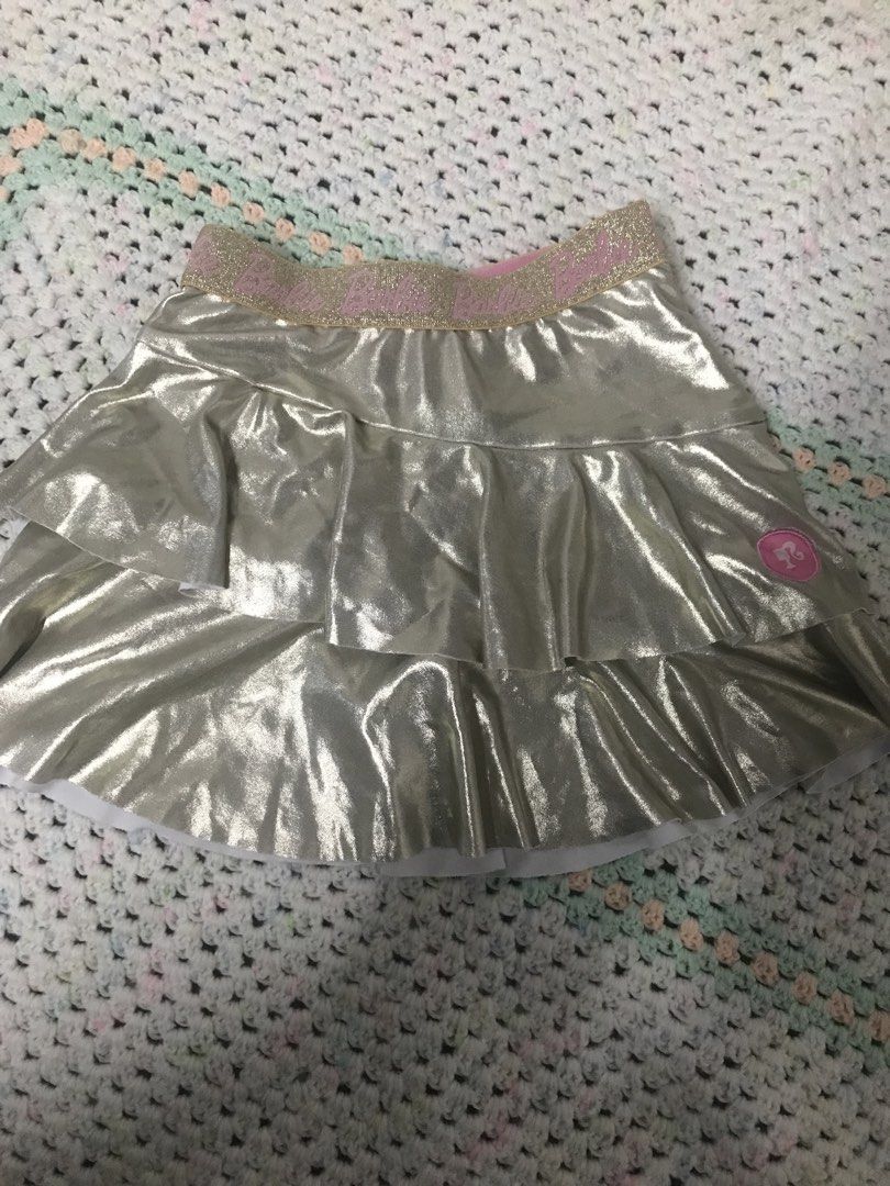 Barbie Gold Ruffle Skirt Size 2 (Category: Babies & Kids Fashion) located in Caloocan City. Submitted by julie_shooooopppp (Listing ID 1462170875, Image 1). Description: - Adorable gold ruffle skirt from Barbie - Features a sparkly pink waistband - Little Barbie logo detail on the side - Perfect for dress-up play or parties - Made in China - Size 2 - Recommended height: 92cm - Recommended waist: 54cm.