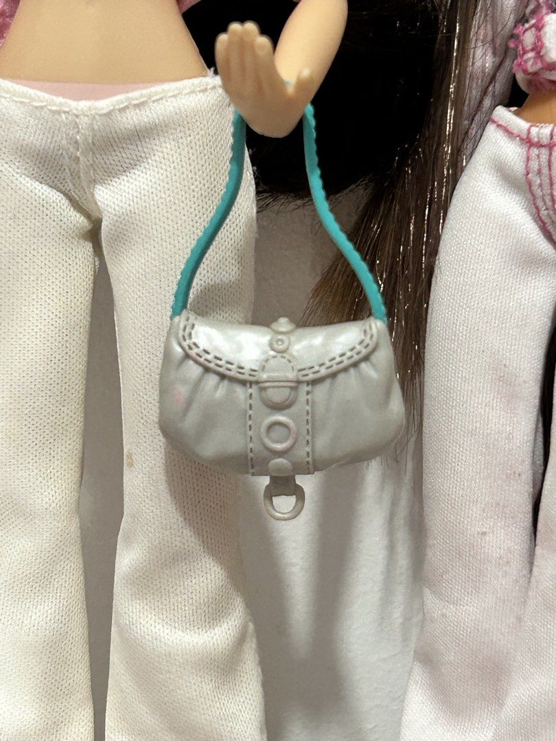 Barbie Grey Doll Handbag with Teal Strap (Category: Purses & Pouches) located in Batangas. Submitted by nommi26 (Listing ID 1462200171, Image 1). Description: - Adorable grey handbag designed for dolls. - Features a stylish teal strap. - Decorative buttons on the flap add a charming detail. - Small ring detail at the bottom. - An excellent accessory to complete any doll's outfit. - Enhances your doll's look and is perfect for imaginative play..