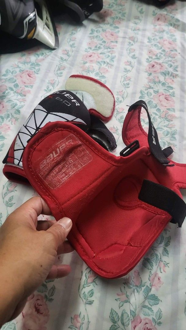 Bauer Hockey Elbow Pads & Knee Pads (Category: Other Sports Equipment and Supplies) located in Caloocan City. Submitted by sparkplug21 (Listing ID 1462104540, Image 2). Description: - Bauer hockey elbow and knee pads - Color: Red, black, and white - Features secure straps for a snug fit - Shows some signs of wear but remains in good playable condition - Suitable for both roller and ice hockey.