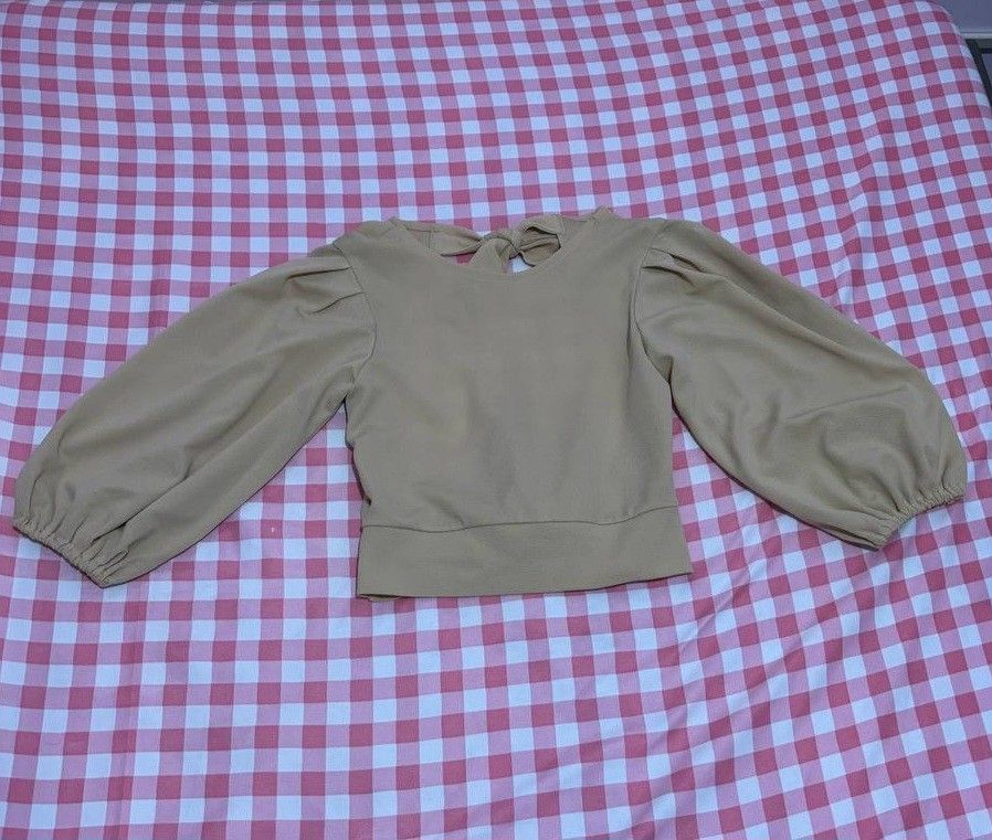 Beige Open-back Top (Category: Blouses) located in Quezon City. Submitted by declutteringnook (Listing ID 1462084535, Image 1). Description: - fits xs to small - with puff sleeves and tie details - fabric is french terry, parang lighter fleece ganun - see pic for when worn - only used once - loc: QC near Fishermall.