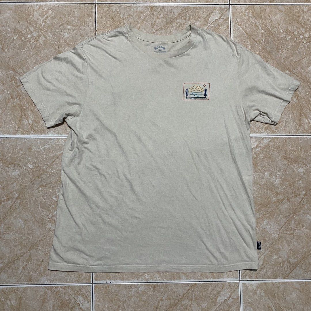 Billabong Adventure Division Tee (Category: Activewear) located in Manila. Submitted by killthismane (Listing ID 1462138183, Image 2). Description: A cream-colored Billabong Adventure Division short-sleeve t-shirt featuring a mountain, ocean, and tree graphic on the back..