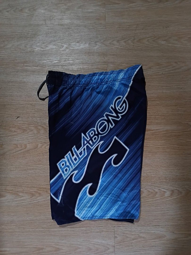 Billabong Board Shorts Blue Gradient (Category: Swim Trunks & Board Shorts) located in Manila. Submitted by givemethat. (Listing ID 1462075698, Image 3). Description: - Brand: Billabong - Design: Blue gradient with wave graphic - Features: Elastic waistband with drawstring - Ideal for: Swimming, lounging, beach trips.