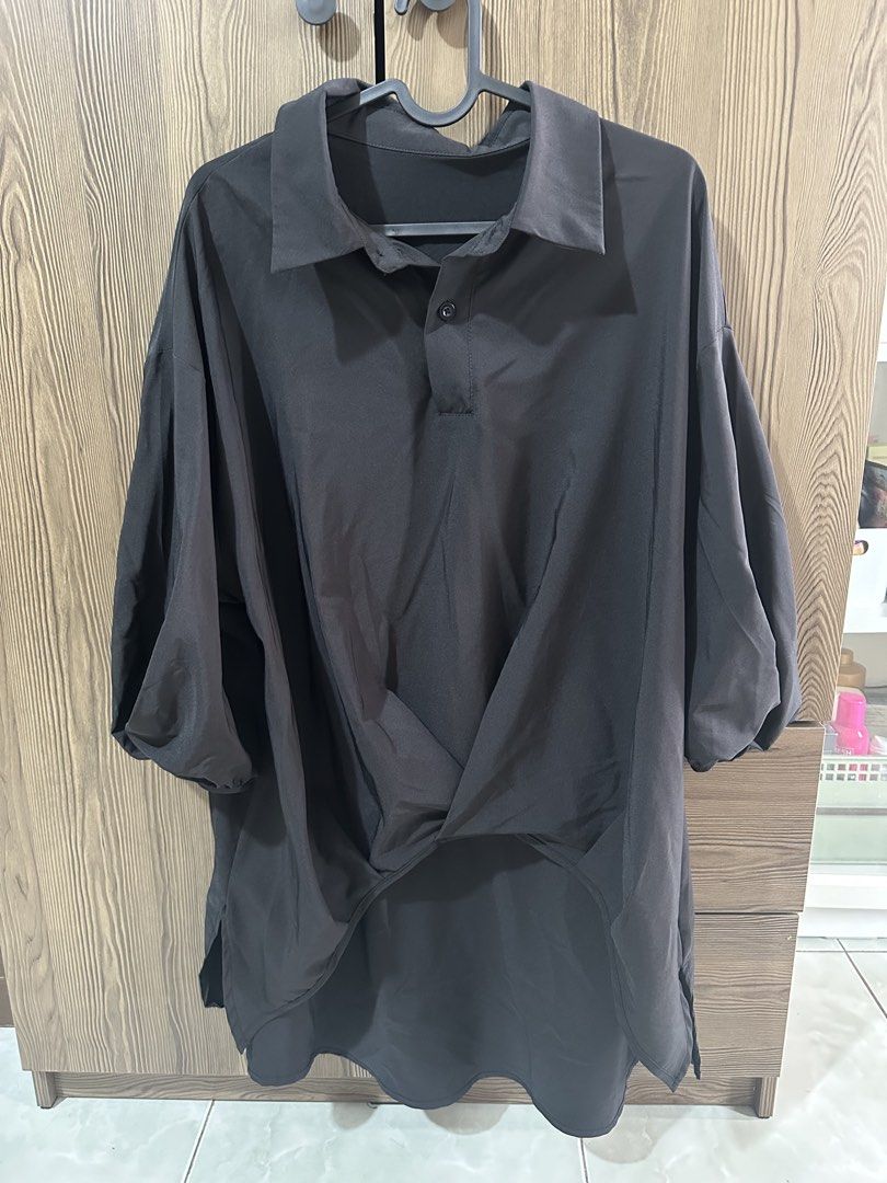 Black Oversized Collared Short Sleeve Shirt (Category: Shirts) located in Paranaque City. Submitted by shopnichoppy (Listing ID 1462125585, Image 2). Description: - Black collared shirt - Short sleeves - Unique twisted detail at the front hem - Relaxed, oversized fit - Side slits for easy movement - Perfect for casual or smart-casual outfits.