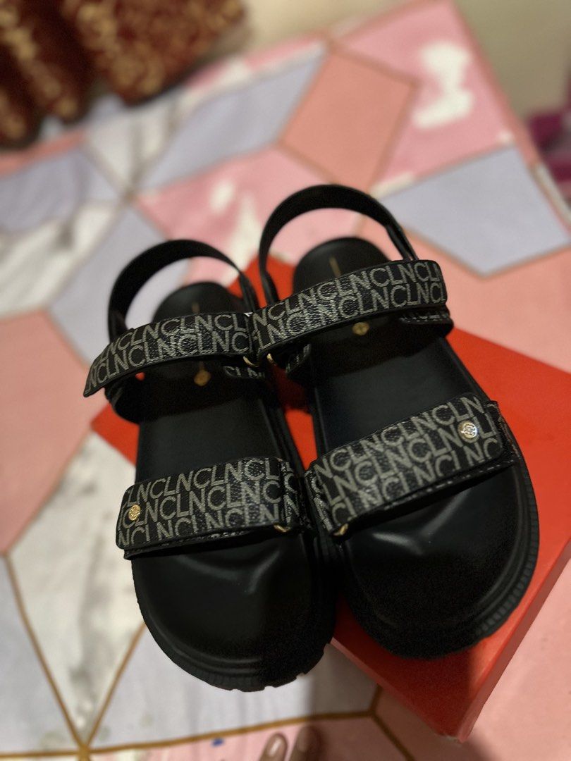 Black Sandals with Monogram Straps (Category: Flats & Sandals) located in Guiguinto. Submitted by marinelcru86104 (Listing ID 1462197692, Image 3). Description: - Stylish black sandals with a repeating monogram pattern on the straps. - Features a comfortable chunky sole for all-day wear. - Adjustable velcro closures for a perfect fit. - Includes the original box. - Ideal for casual outings and everyday comfort..