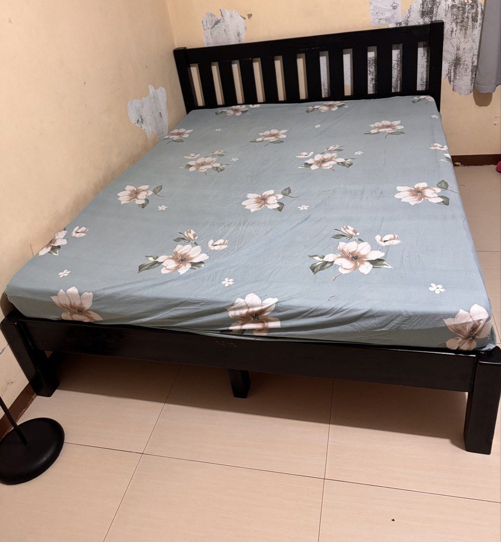 Black Wooden Bed Frame with Floral Bedding (Category: Bed Frames & Mattresses) located in Manila. Submitted by chicmom.of.3 (Listing ID 1462089375, Image 1). Description: - Sturdy black wooden bed frame - Approximately 150cm wide - Includes a light blue fitted sheet with a floral pattern - Ready for its new home!.