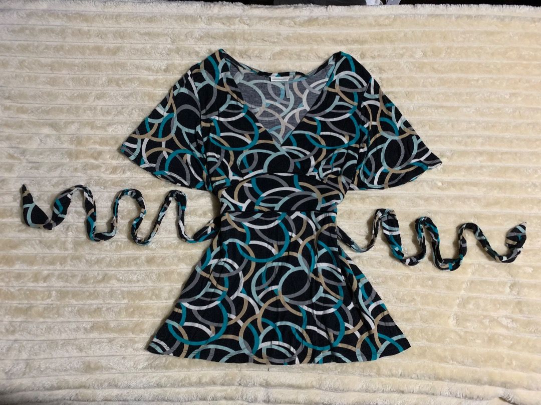 Black Wrap top with Abstract Circle Print and Tie (Category: Luxury Apparel) located in Caloocan City. Submitted by emmalizz (Listing ID 1462210621, Image 1). Description: - Short-sleeved wrap dress - Black base with abstract circle print (teal, beige, grey) - Includes matching tie belt for adjustable waist - Flutter sleeves for a feminine touch - Versatile for casual or dressed-up looks.