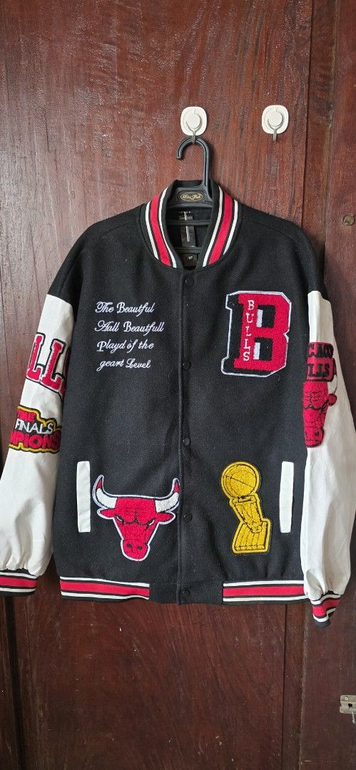Boston Celtics & Chicago Bulls NBA Varsity Jacket (Category: Coats, Jackets and Outerwear) located in Santa Maria. Submitted by ellahqy28 (Listing ID 1462182437, Image 2). Description: - 🔥 2-in-1 Varsity Jacket: Rock both Boston Celtics & Chicago Bulls styles! - Sleek black body with classic leather sleeves. - Features iconic Celtics green/white trim and Bulls red/white trim. - Loaded with cool patches and detailed embroidery. - A must-have for 