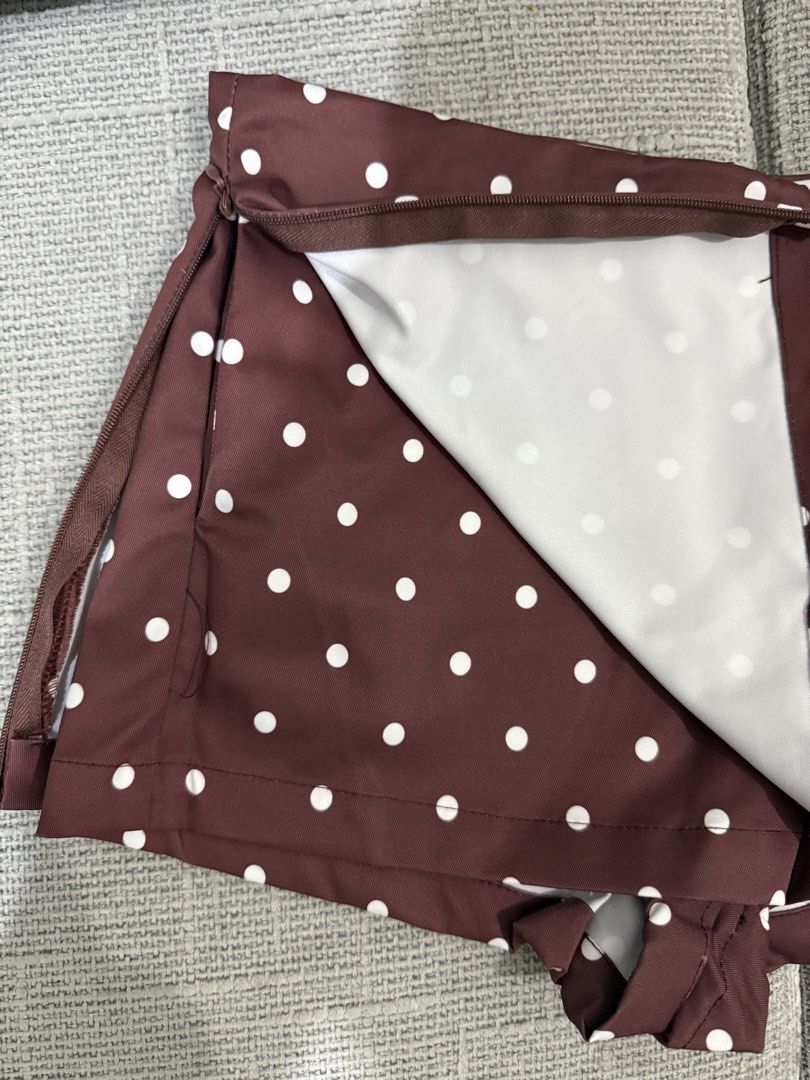 Brown Polka Dot Skirt with Zipper (Category: Skirts) located in Pasig City. Submitted by rchsh (Listing ID 1462136410, Image 2). Description: - Brown skirt with white polka dots - Side zipper closure - Inner shorts with pockets - Likely polyester blend fabric - Versatile for casual or dressed-up looks - Easy to pair with various tops.