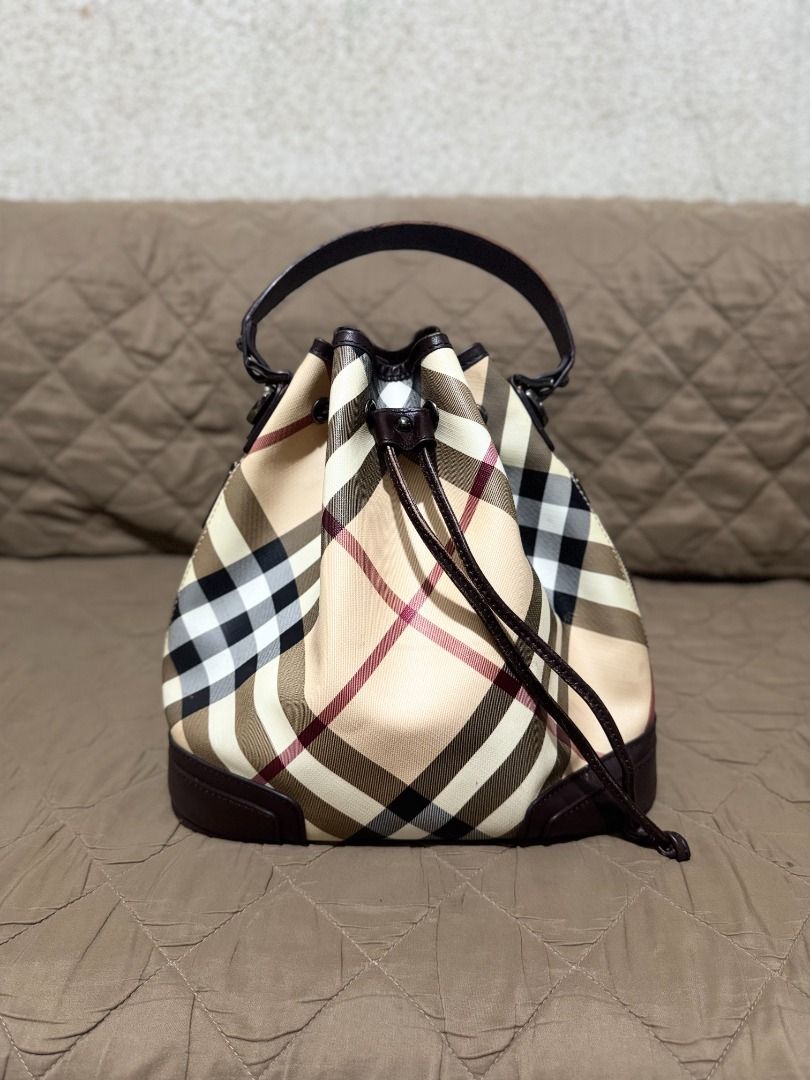 BURBERRY NOVA BUCKET BAG (Category: Luxury Bags & Wallets) located in San Pablo. Submitted by calmhawk.60c993 (Listing ID 1462137463, Image 1). Description: Burberry Nova Check drawstring bucket bag, highlighted by its distinctive dark leather trim and cinch-cord closure... JUST a rubber lining minor issue.