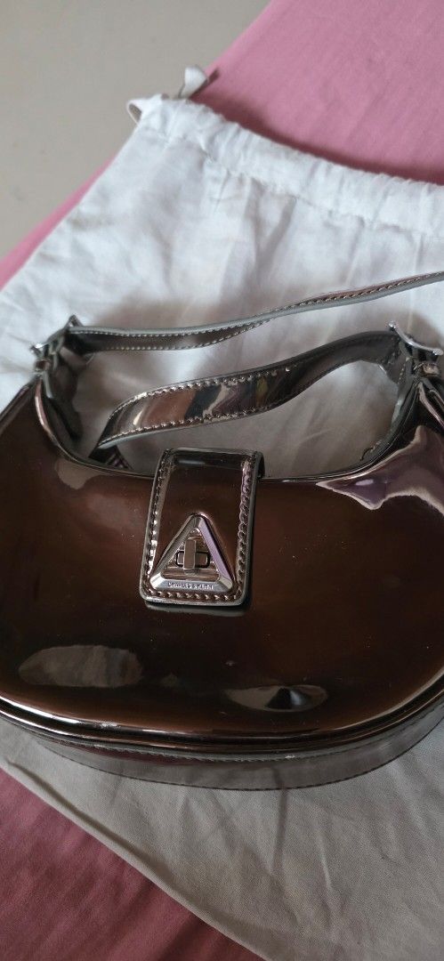 Charles & Keith Patent Shoulder Bag (Category: Shoulder Bags) located in Santa Maria. Submitted by ellahqy28 (Listing ID 1462191397, Image 2). Description: - Brand: Charles & Keith - Style: Shoulder Bag - Material: Shiny Patent - Color: Metallic Brown - Closure: Flap with silver buckle detail - Includes: Dust bag - Perfect for: Nights out, adding a pop to your outfit.